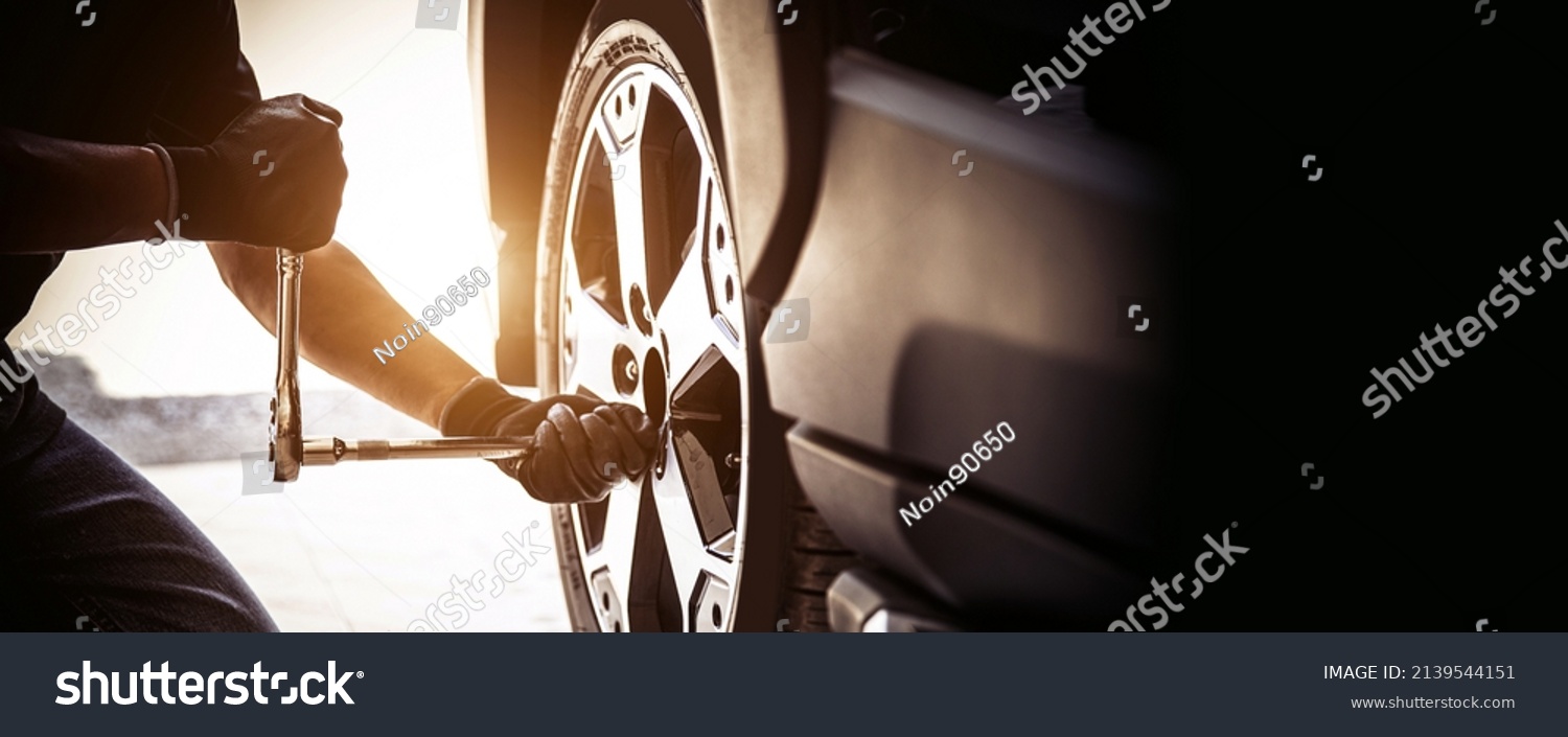 stock-photo-auto-mechanic-use-wrench-to-repairing-and-change-car-tires-concept-of-car-care-service-and-2139544151.jpg